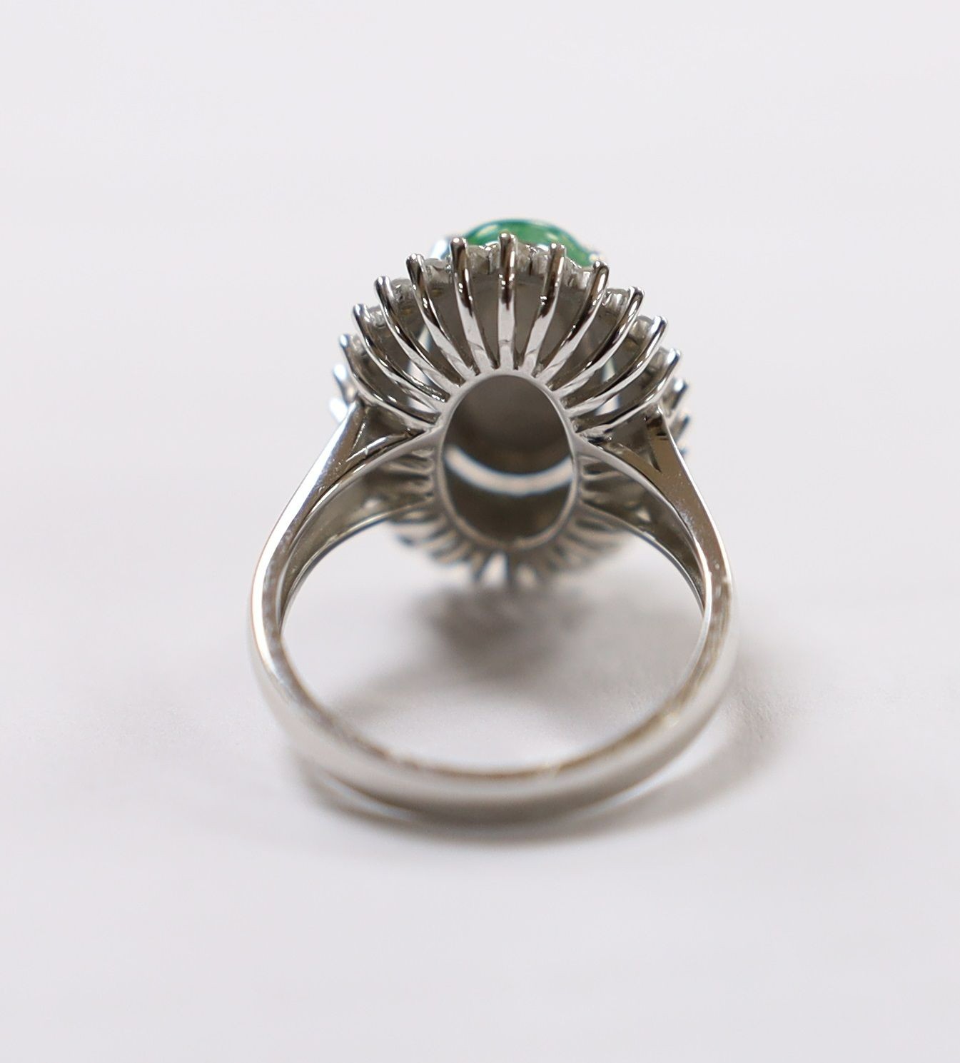 A modern 18k white metal, cabochon jade and two row diamond chip set oval cluster ring size L, gross weight 6.4 grams.